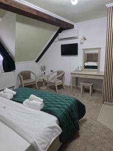 a bedroom with a bed and a desk and a television at Pensiunea La Cetate in Târgu Neamț +35 photos