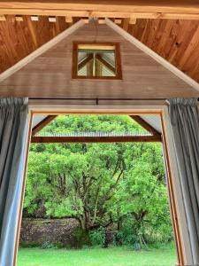 a window in a house with a wooden roof at RIMU CABIN At the Bridge in Motungarara