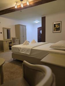 a hotel room with two beds and a bathroom at Pensiunea La Cetate in Târgu Neamț
