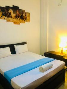 a bedroom with a bed and a lamp on a table at Lotus cool hotel and restaurant in Ibbagomuwa