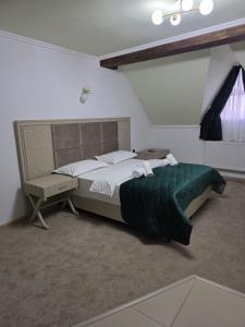 a bedroom with a bed and a desk and a bed sidx sidx sidx at Pensiunea La Cetate in Târgu Neamț