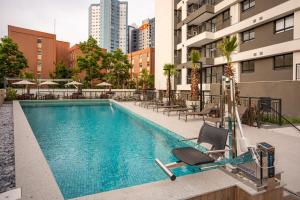 een zwembad met ligstoelen en een gebouw bij Solar Explore Botanico in Curitiba