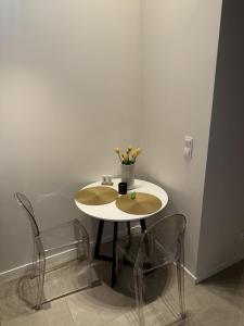 un tavolo bianco con due sedie e un vaso sopra di Old Town Pomorska Luxury Apartment a Breslavia