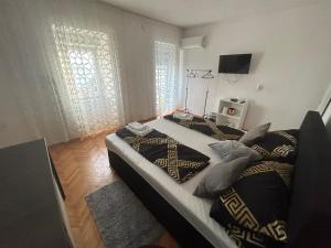 een slaapkamer met twee bedden en een televisie bij Kuća za odmor Dramalj in Dramalj