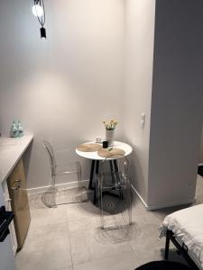 tavolo e sedie in una stanza con parete bianca di Old Town Pomorska Luxury Apartment a Breslavia