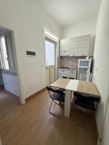 a kitchen with a wooden table and two chairs at Case Vacanze nonna Elisa in Avola