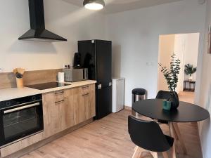 cocina con mesa y nevera negra en Doux Pavillon - La suite Hirvi - Hyper centre, en Roanne