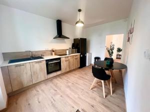Una cocina con una mesa y una encimera negra. en Doux Pavillon - La suite Hirvi - Hyper centre, en Roanne