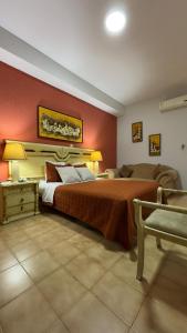 a bedroom with a large bed and a couch at Hotel Dinastía in San Cristóbal