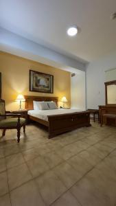 a large bedroom with a bed and a chair at Hotel Dinastía in San Cristóbal