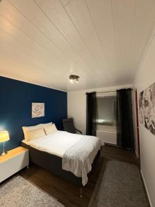Un dormitorio con una cama grande y una pared azul. en Cozy house near the river - sauna, Wi-Fi, en Tornio