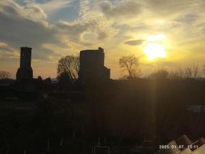 a sunset over a city with the sun in the sky at Vár-Liget Vendégház in Kisnána