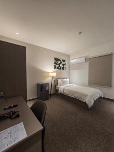 Baghdad Business Hotel - فندق اعمال بغداد في بغداد: غرفة فندق بها سرير ومكتب