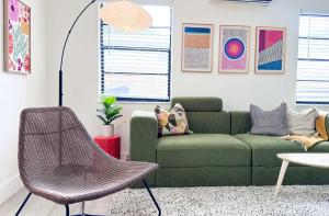 een woonkamer met een groene bank en een tafel bij Cloud Nine - Wilton Drive Jacuzzi Backyard in Fort Lauderdale