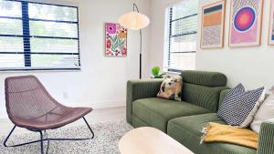 een woonkamer met een groene bank en een stoel bij Cloud Nine - Wilton Drive Jacuzzi Backyard in Fort Lauderdale