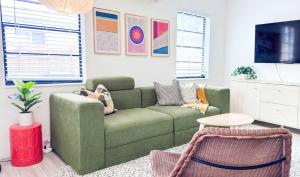 een woonkamer met een groene bank en een tafel bij Cloud Nine - Wilton Drive Jacuzzi Backyard in Fort Lauderdale