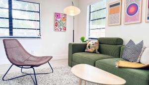 een woonkamer met een groene bank en een tafel bij Cloud Nine - Wilton Drive Jacuzzi Backyard in Fort Lauderdale +16 foto's