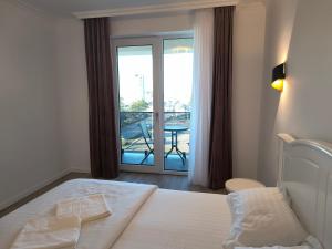a bedroom with a bed and a balcony with a table at Twin Constantin-Apartment in Suceava