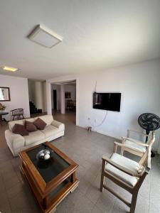 ペトロリーナにあるCasa agradável em Petrolina, alugue com Sevé!のソファとテーブルと椅子のあるリビングルーム