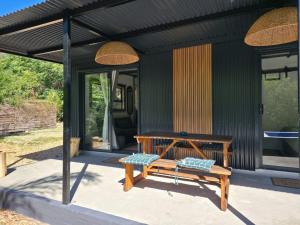 a wooden bench sitting outside of a house at Luxury Unit with Mountain Views & Splash Pool in Oudtshoorn
