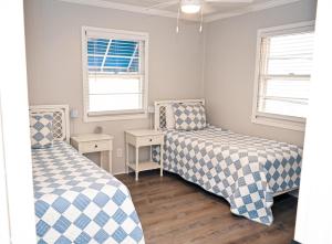 two beds in a room with two windows at The Salty Lime in Emerald Isle