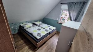 Bett in einem kleinen Zimmer mit Fenster in der Unterkunft Ferienhaus Burgblick in Blankenburg in Michaelstein
