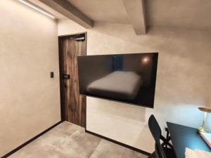 a room with a flat screen tv on the wall at Fukuchiya in Fujiyoshida