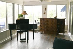 a living room with a piano and a desk at The Salty Lime in Emerald Isle +10 photos