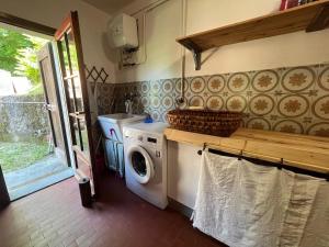 a laundry room with a washing machine and a sink at Casa con giardino e vista sulle montagne in Cutigliano