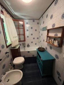 a bathroom with a toilet and a sink and a tub at Casa con giardino e vista sulle montagne in Cutigliano +32 photos