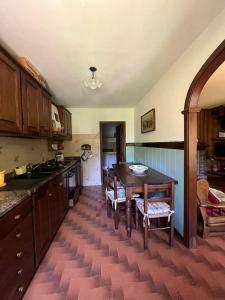 a kitchen with a wooden table and a tableasteryasteryasteryasteryasteryasteryastery at Casa con giardino e vista sulle montagne in Cutigliano