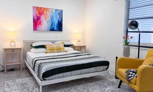 een slaapkamer met een bed en een gele stoel bij The Hideaway - Wilton Manors in Fort Lauderdale