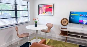 een woonkamer met een tafel en stoelen en een televisie bij The Hideaway - Wilton Manors in Fort Lauderdale