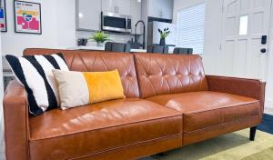 een bruine leren bank met twee kussens erop bij The Hideaway - Wilton Manors in Fort Lauderdale +13 foto's