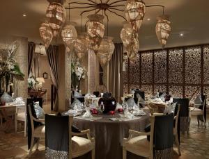 a dining room with tables and chairs and chandeliers at Royal Garden Villas, Luxury Hotel in Adeje