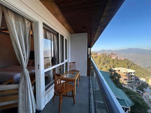 a balcony with a table and chairs and a view at Dwaper Palace A Luxury Property Near Library Chowk, Mussoorie in Mussoorie