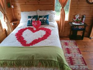 a bed with a heart made out of flowers at Cabaña Los Linos in Guasca