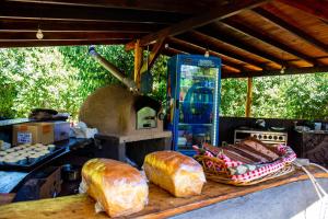 a table with some bread and an oven with loaves of bread at Camping Aiton Amunak in El Bolsón