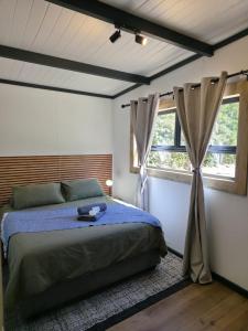 a bedroom with a bed with a blue comforter and two windows at Luxury Unit with Mountain Views & Splash Pool in Oudtshoorn +10 photos