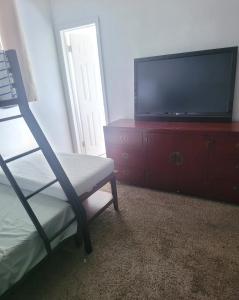 een kamer met een televisie en een dressoir met een stoel bij LakePoolBeachVacatuonHouse225d9Prs 