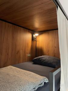 a bedroom with a bed with a wooden wall at Downtown River Hostel in Donostia-San Sebastián