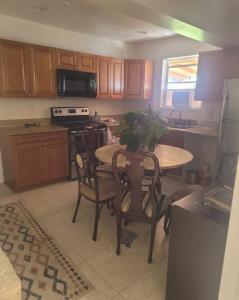 een keuken met een houten tafel met stoelen en een spoelbak bij LakePoolBeachVacatuonHouse225d9Prs 