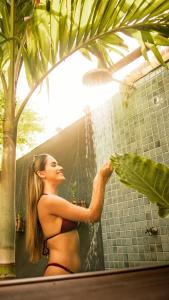 uma mulher de biquíni em pé num chuveiro com água em Refugio Do Morro - Morro São Paulo em Morro de São Paulo
