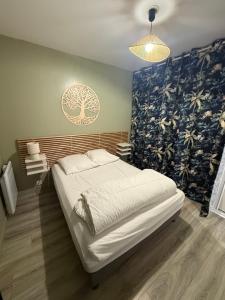 een slaapkamer met een groot bed met een blauwe muur bij 2 PIECES CENTRE ET MER in Cabourg