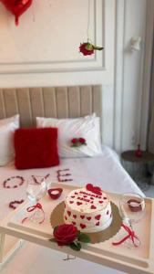 una torta su un vassoio su un letto con bicchieri di vino di Le Paradis Du Figuier a Boumerdès