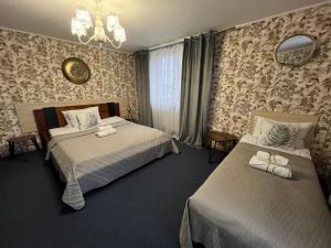 Un dormitorio con dos camas y una lámpara de araña. en Villa Zdrojowa, en Otmuchów