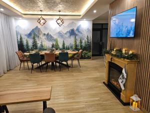 a dining room with a table and a fireplace at Wolf Chalet - Moieciu de Sus in Moieciu de Sus