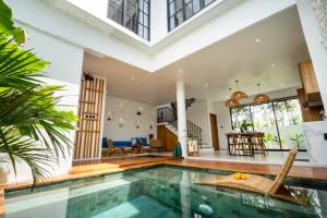 ein Innenpool in einem Haus mit Wohnzimmer in der Unterkunft Bali Taoka Villa Tanah Lot in Tanah Lot