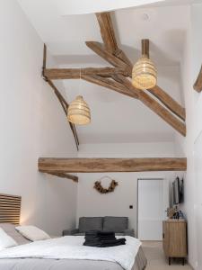 Un dormitorio con paredes blancas y vigas de madera. en Suite avec balnéothérapie, en Montholon 14 fotos más