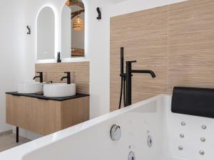 ein Badezimmer mit zwei Waschbecken und einer Badewanne in der Unterkunft Suite avec balnéothérapie in Montholon